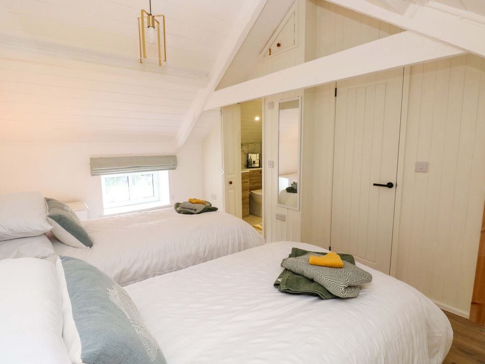 A bedroom with two beds and towels at Graig Goch in Burry Port