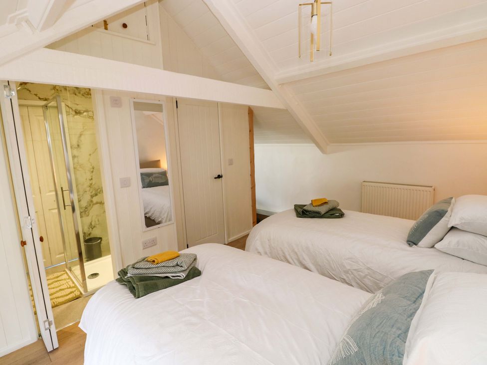 A bedroom with two beds and a shower at Graig Goch in Burry Port