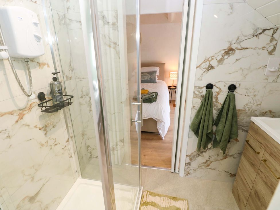 A bathroom with a shower and towels at Graig Goch Burry Port