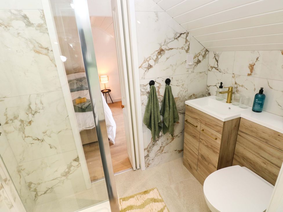 A bathroom with a shower and sink at Graig Goch in Burry Port