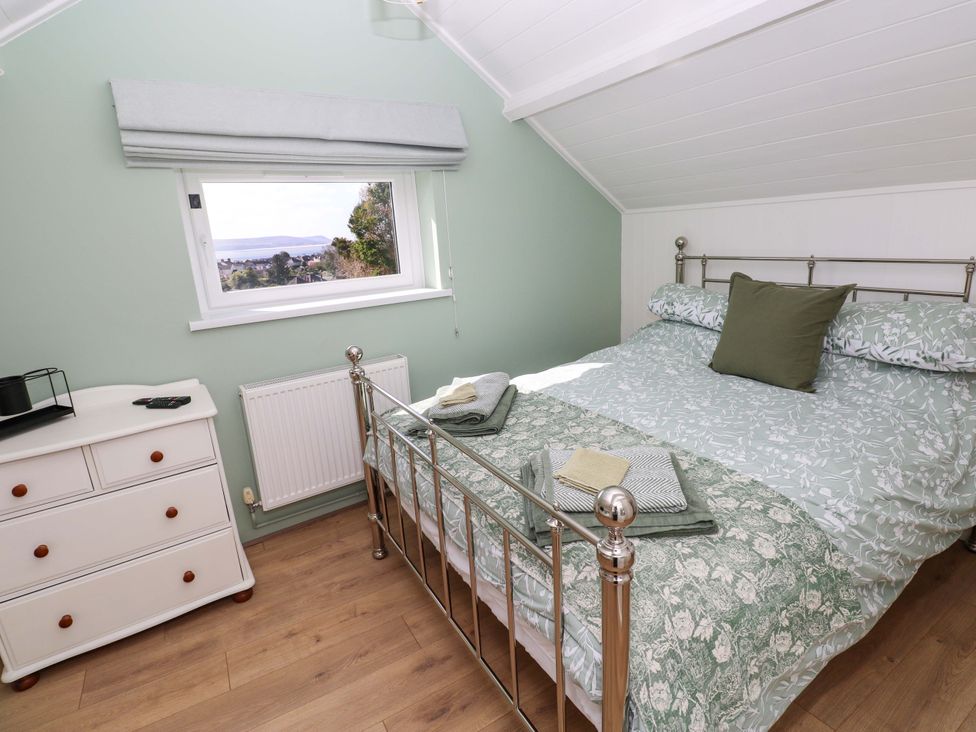 A bedroom with a bed and dresser at Graig Goch in Burry Port
