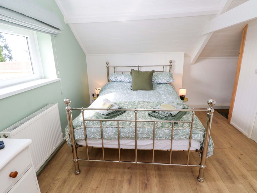 A bedroom with a double bed and a window at Graig Goch in Burry Port