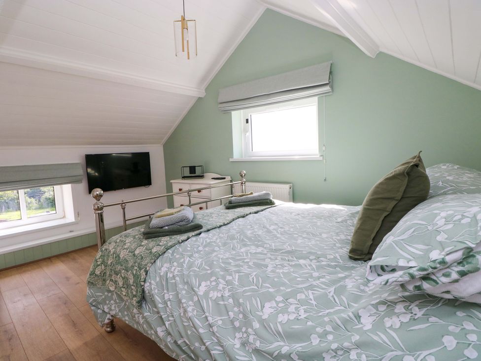 A bedroom with a bed and television at Graig Goch in Burry Port