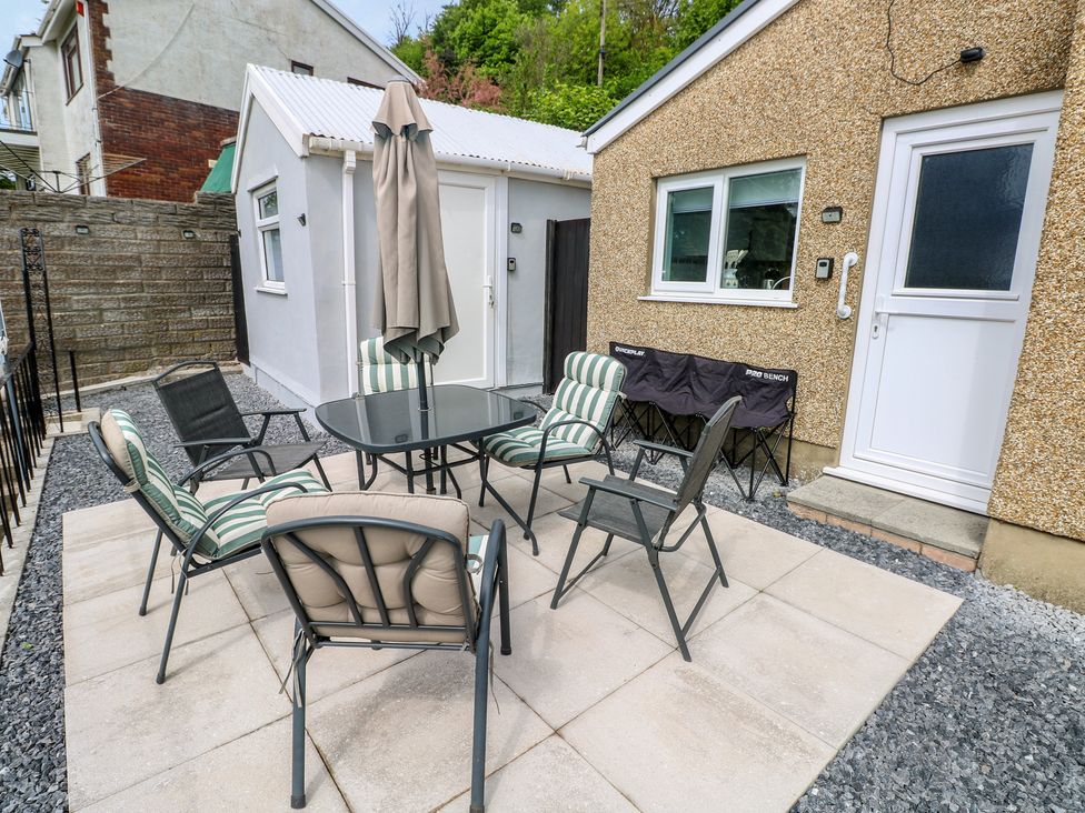 An outdoor seating area with chairs and a table at Graig Goch in Burry Port