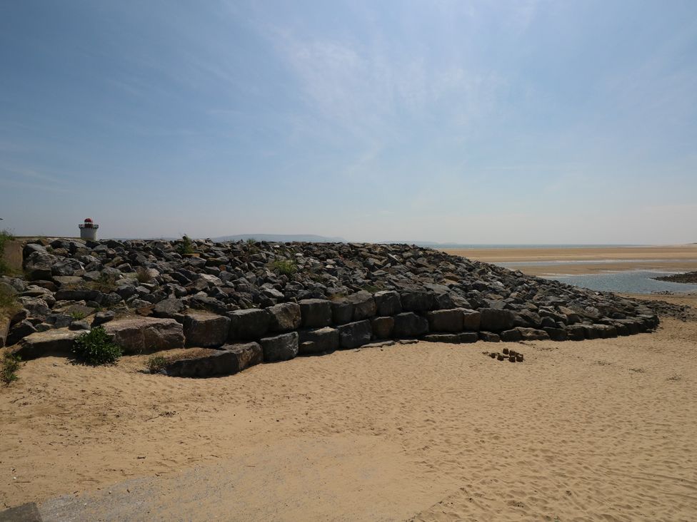 A shoreline with rocks and a lighthouse at Graig Goch, Burry Port