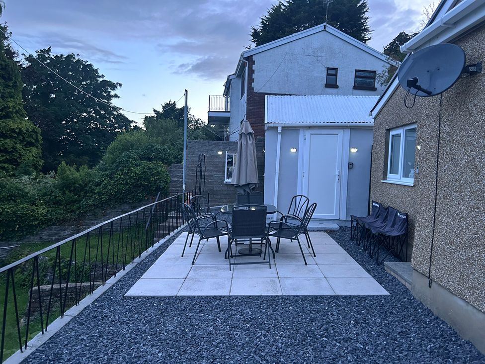 An outdoor seating area with table and chairs at Graig Goch in Burry Port