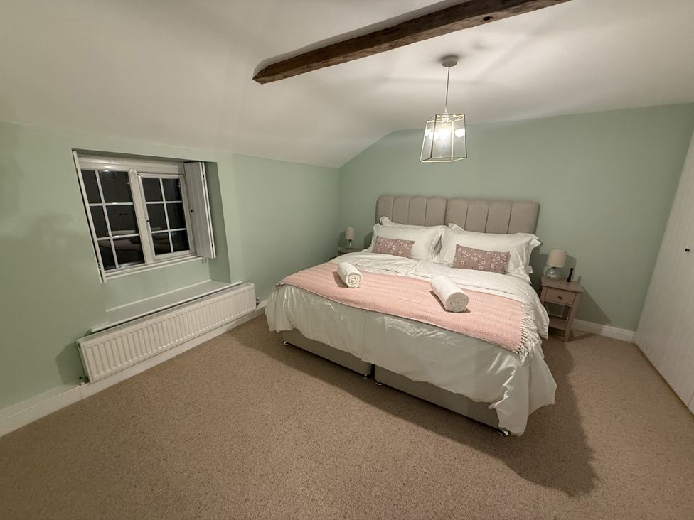 A bedroom with a double bed and window at Woodman's Cottage in Newmillerdam