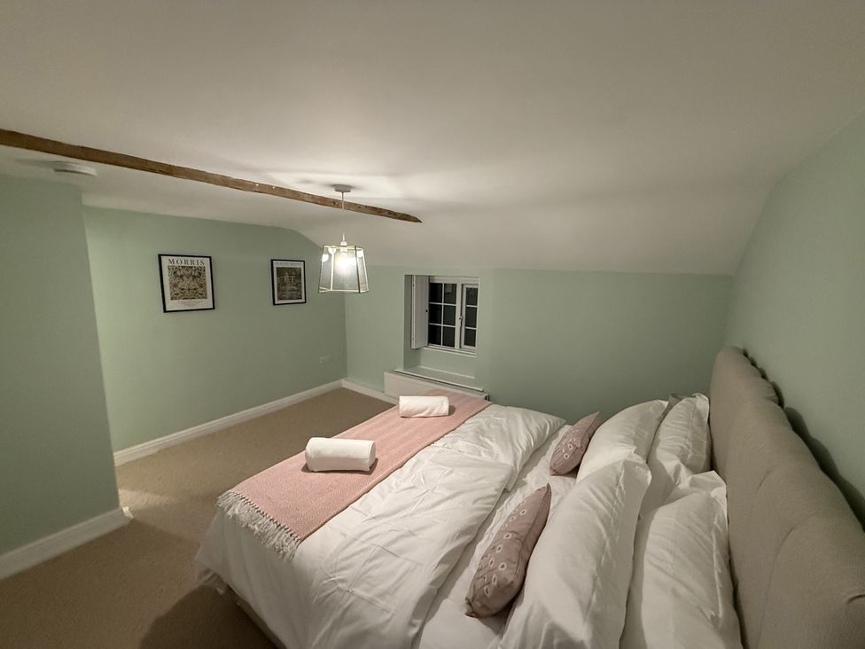 A bedroom with a bed and towels at Woodman's Cottage in Newmillerdam