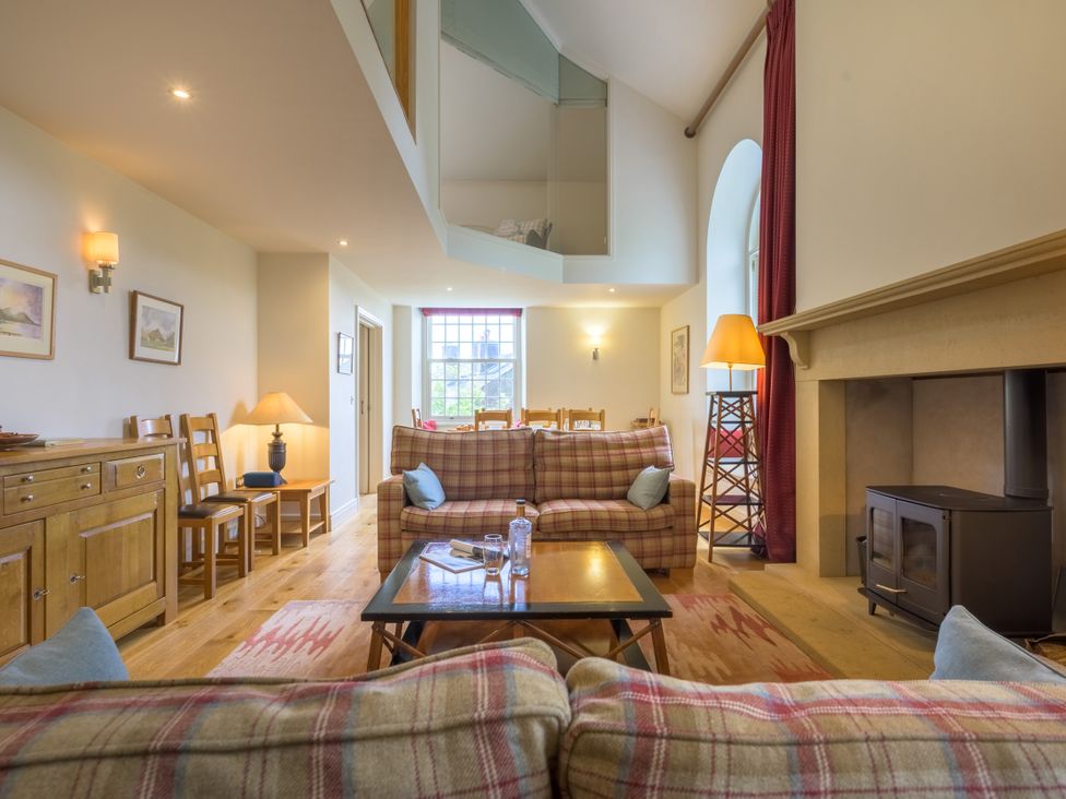 A living room with sofas and a fireplace at The School in Mungrisdale near Caldbeck