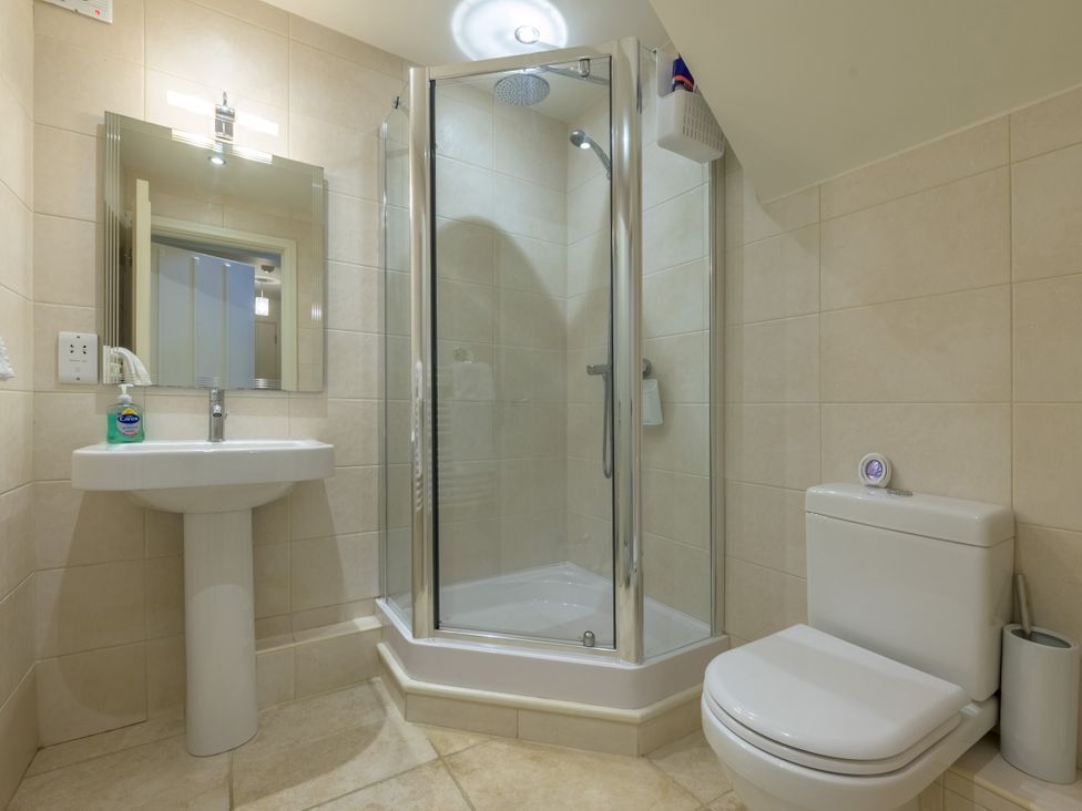 A bathroom with a shower, toilet, and sink at The School in Mungrisdale near Caldbeck