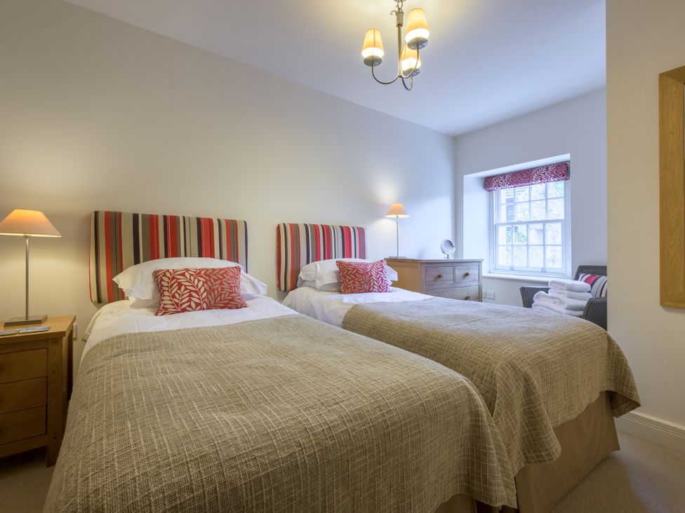 A bedroom with two twin beds and a window at The School in Mungrisdale near Caldbeck