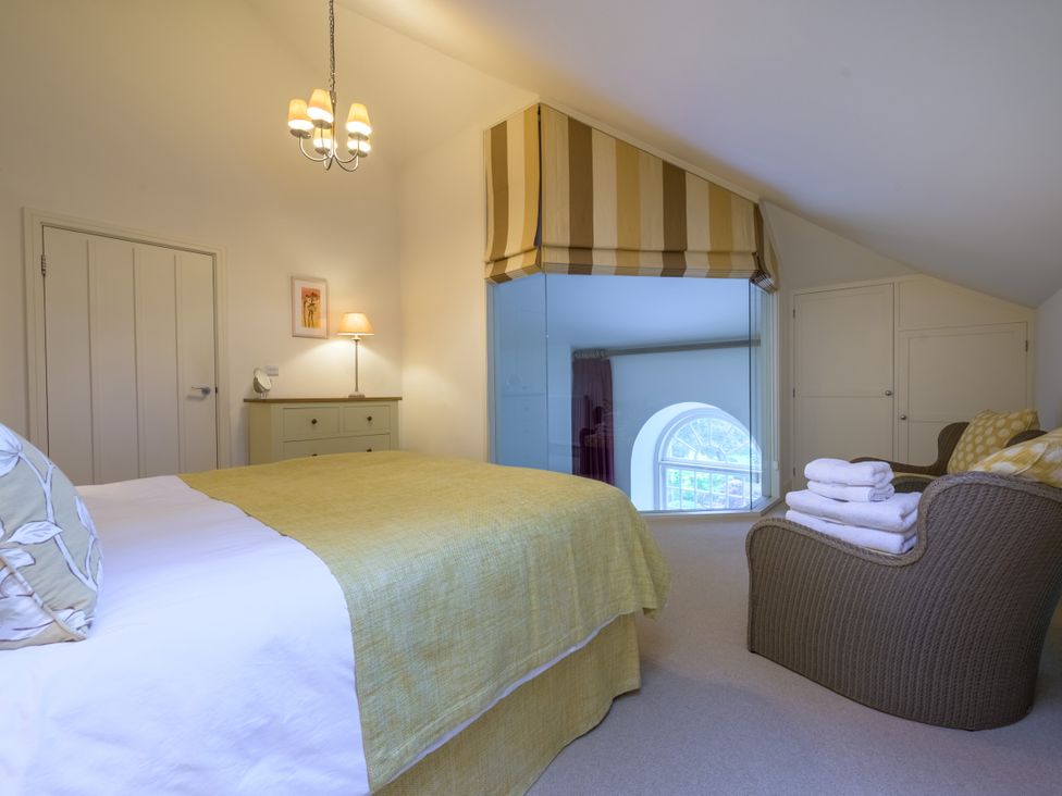 A bedroom with a bed and chair at The School in Mungrisdale near Caldbeck