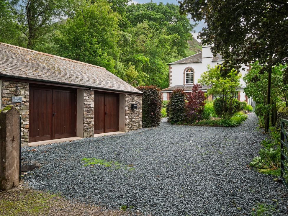 An outdoor scene featuring a garage and gravel driveway at The School in Mungrisdale near Caldbeck