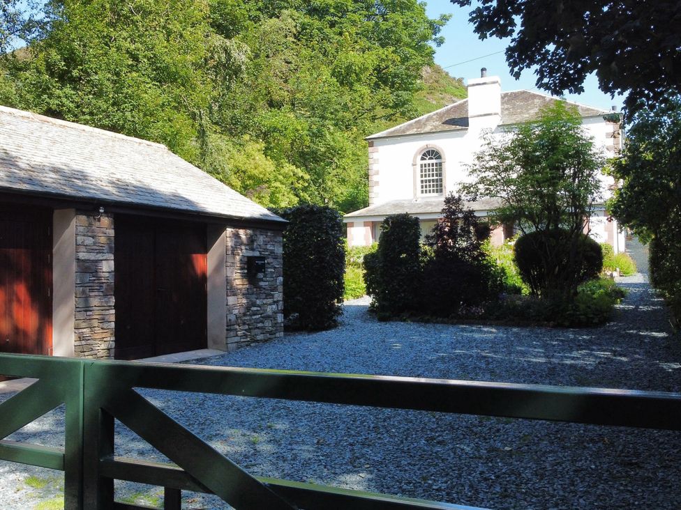 A garage and house with a gravel driveway at The School at Mungrisdale in Mungrisdale near Keswick