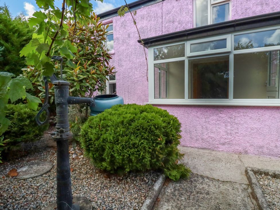 An outdoor area with a pump and shrubs at Brockstone Cottage in St Austell