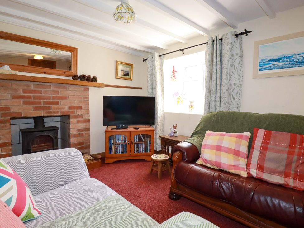 A living room with a sofa and a television at Brockstone Cottage St Austell