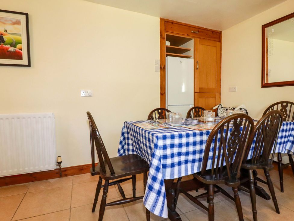 A dining room with a table and chairs at Brockstone Cottage in St Austell