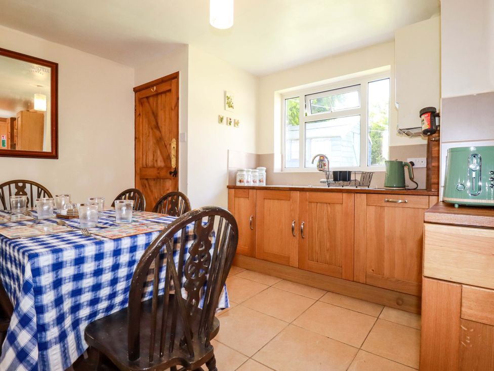 A kitchen with a dining table and chairs at Brockstone Cottage in St Austell