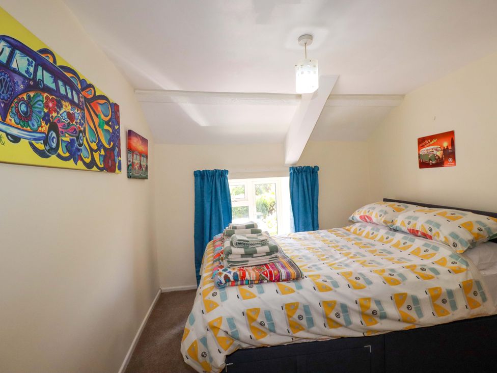 A bedroom with a bed and window at Brockstone Cottage St Austell