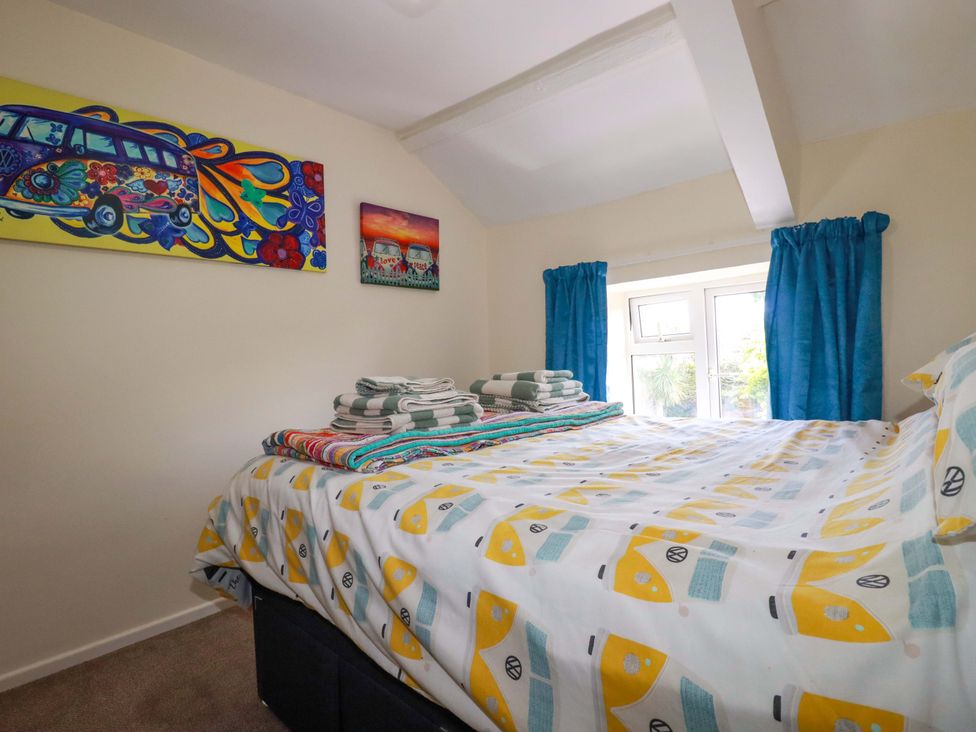 A bedroom with a bed and towels at Brockstone Cottage in St Austell