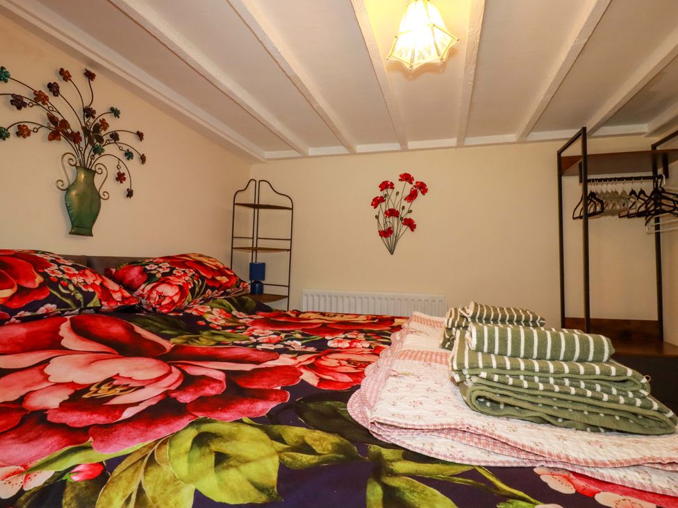 A bedroom with a bed and decorative elements at Brockstone Cottage in St Austell