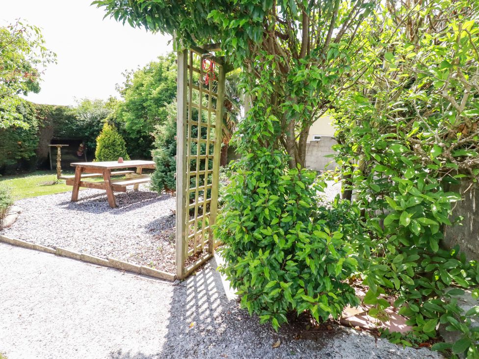 A garden with a table and plants at Brockstone Cottage in St Austell