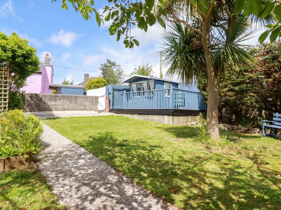 An outdoor area with a garden and a deck at Brockstone Cottage in St Austell