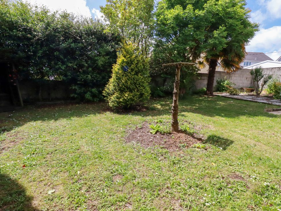 A garden with grass and trees at Brockstone Cottage in St Austell