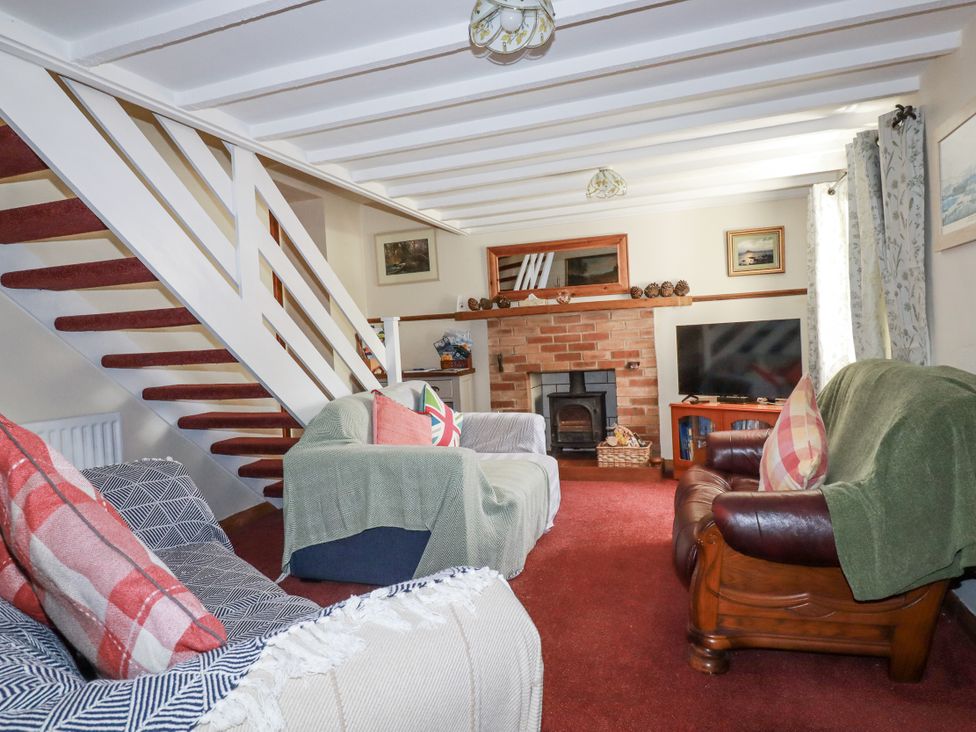 A living room with a fireplace and sofa at Brockstone Cottage in St Austell