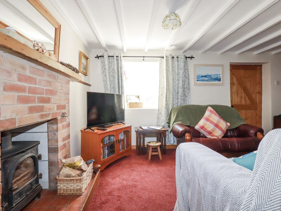 A living room with a television and sofa at Brockstone Cottage in St Austell