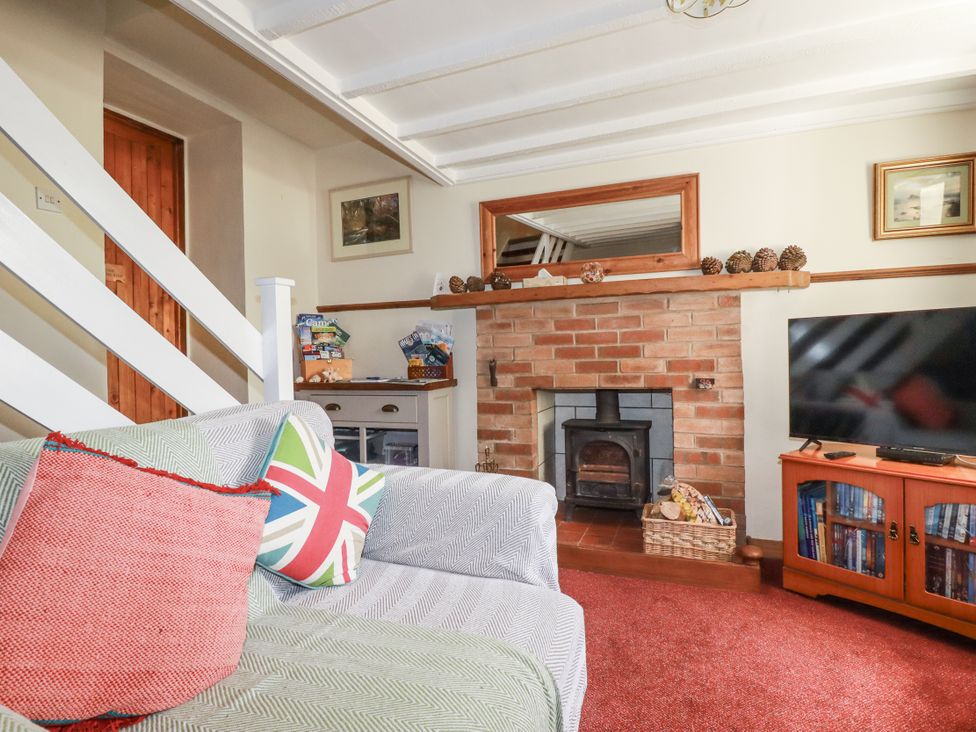 A living room with a sofa and fireplace at Brockstone Cottage St Austell