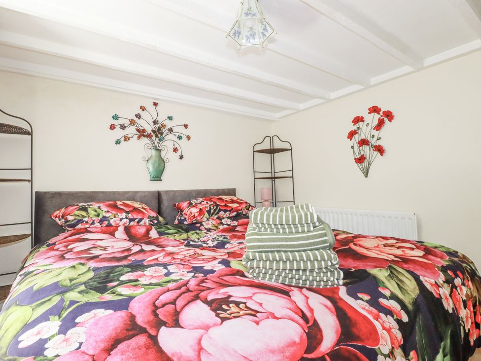 A bedroom with a bed and decorative items at Brockstone Cottage in St Austell