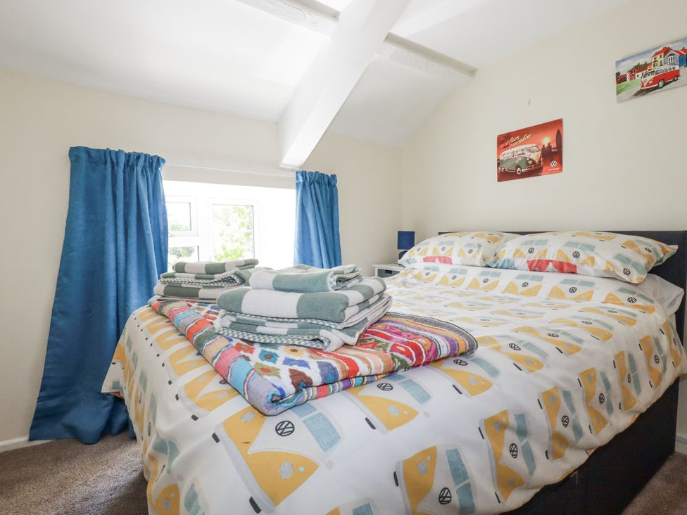 A bedroom with a bed and towels stacked at Brockstone Cottage St Austell
