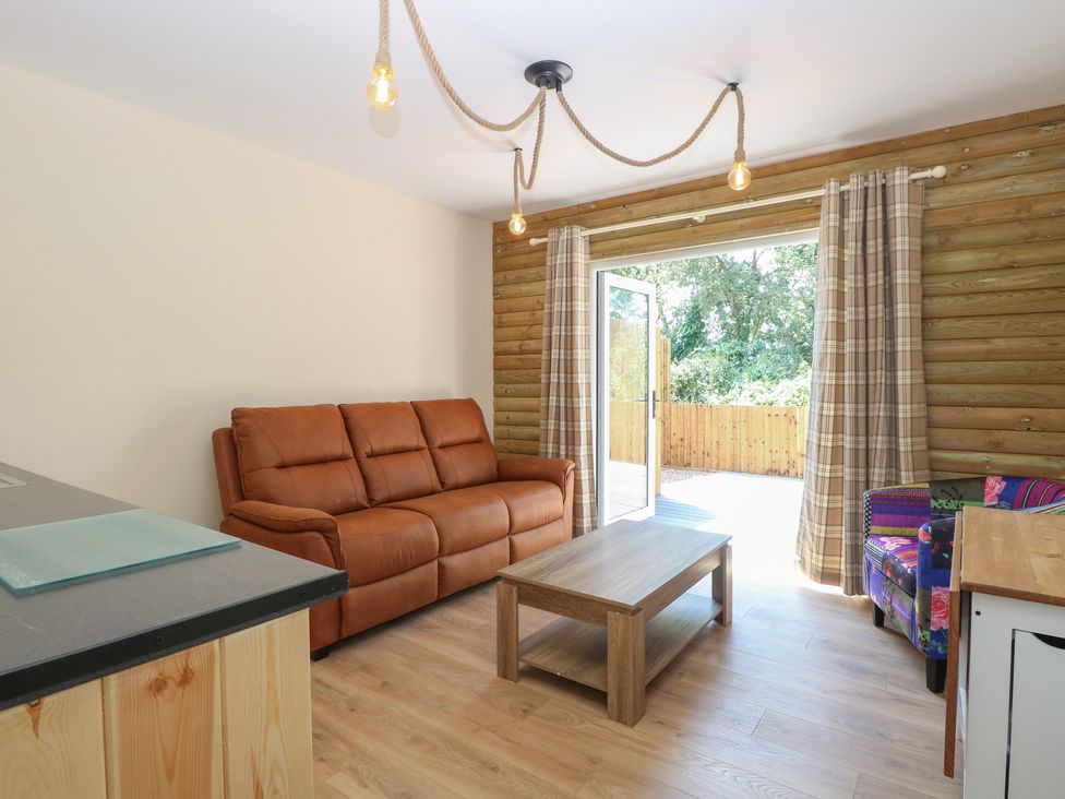 A living room with a sofa and coffee table at Barn Owl Lodge