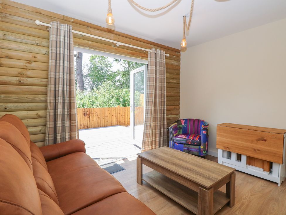 A living room with a sofa and coffee table at Barn Owl Lodge