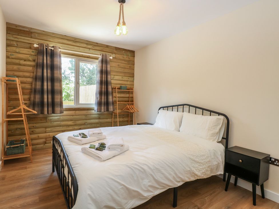 A bedroom with a bed and window at Barn Owl Lodge