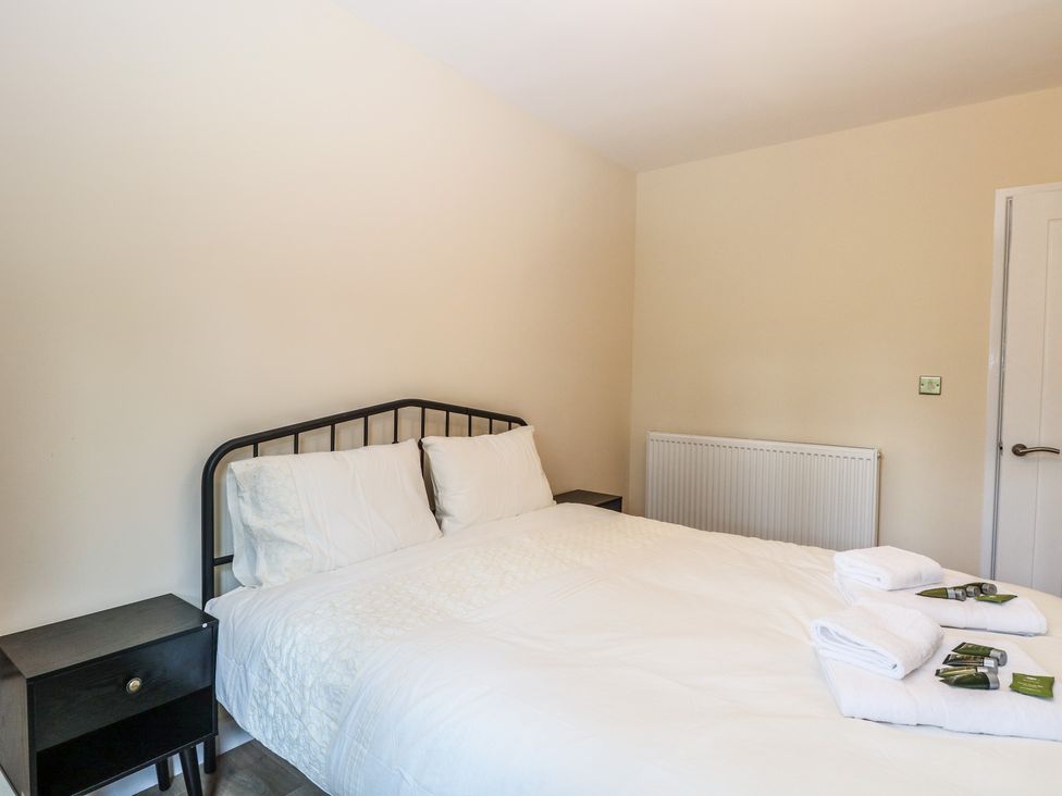 A bedroom with a bed and nightstand at Barn Owl Lodge