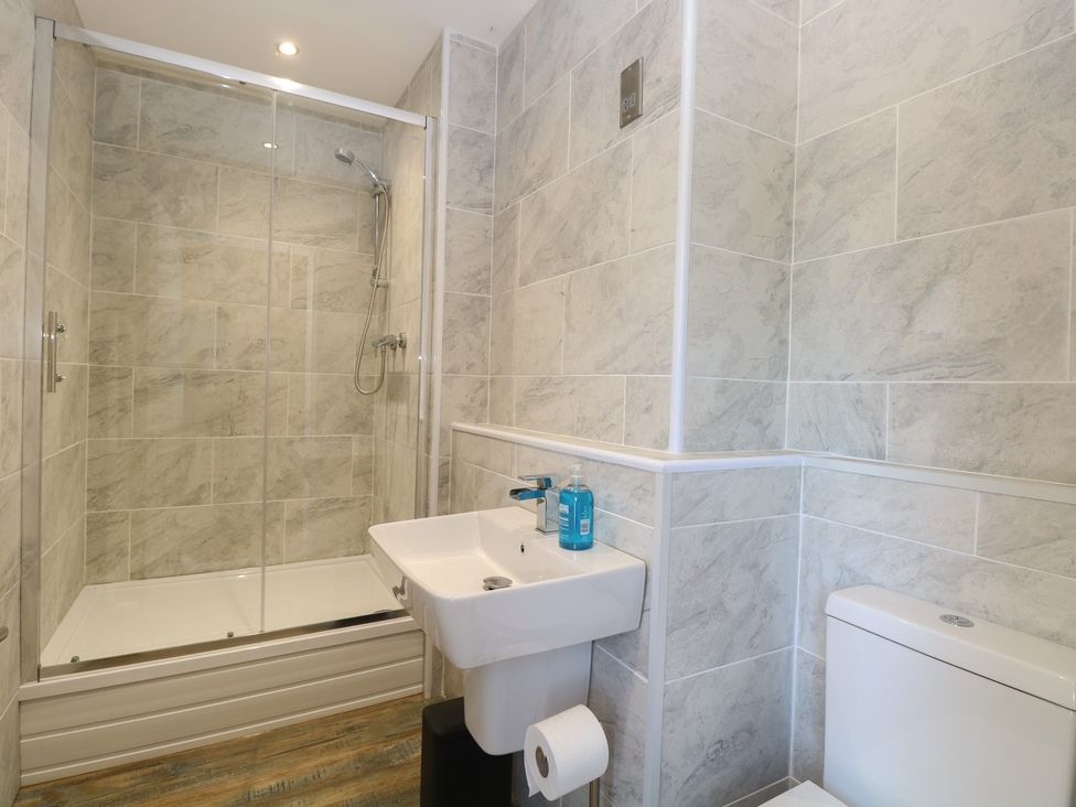 A bathroom with a shower, sink and toilet at Barn Owl Lodge