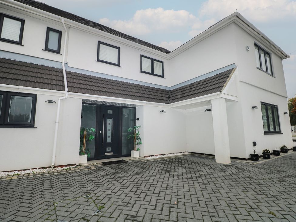 A house entrance with a driveway and potted plants at Falcon Bal House