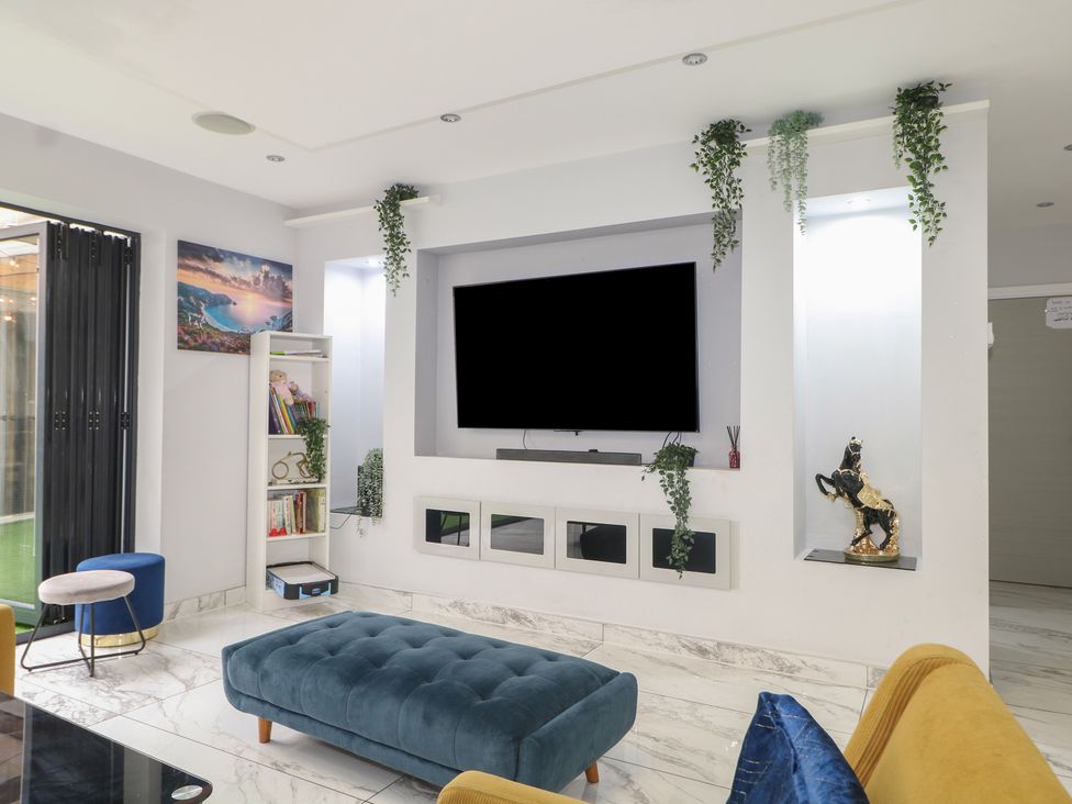 A living room with a tv mounted on the wall at Falcon Bal House