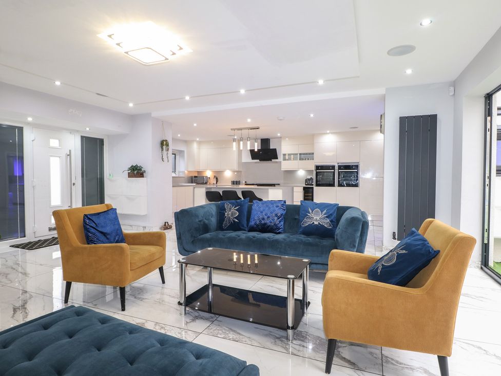 A living room with a blue sofa and orange armchairs at Falcon Bal House