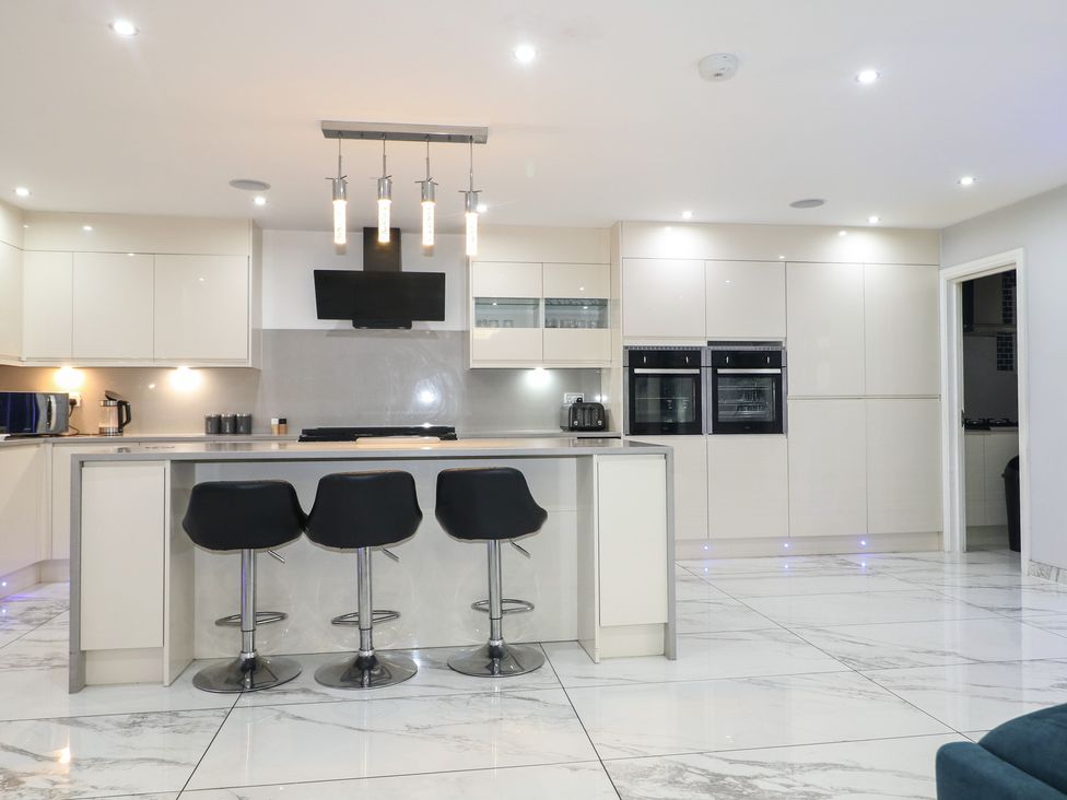 A kitchen with an island and bar stools at Falcon Bal House 