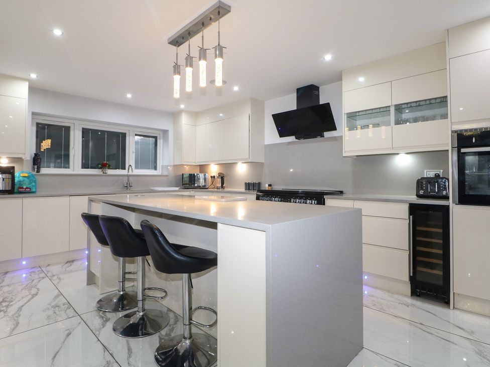 A kitchen with a central island and modern appliances at Falcon Bal House