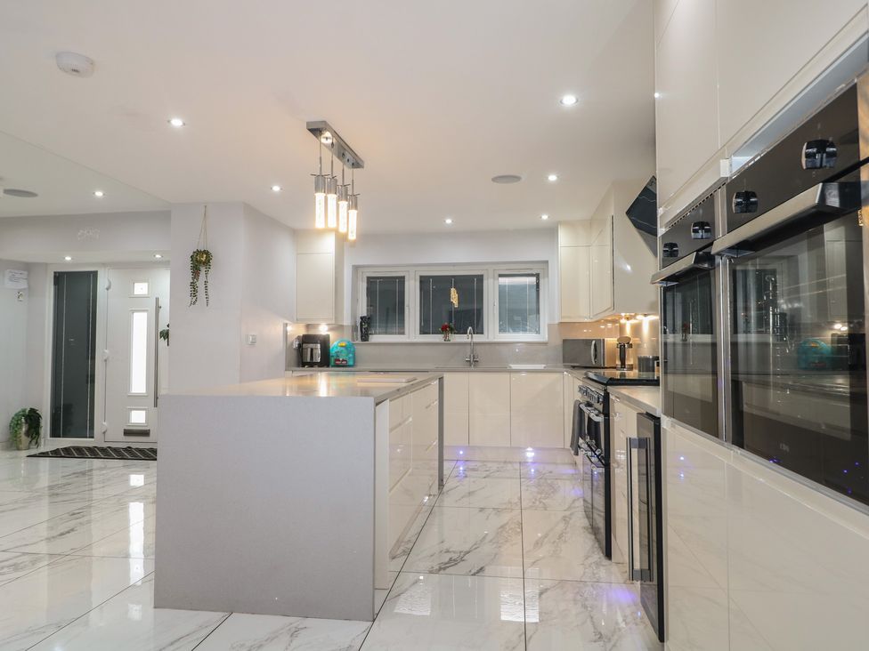 A kitchen with cabinets, oven, sink, and kitchen island at Falcon Bal House