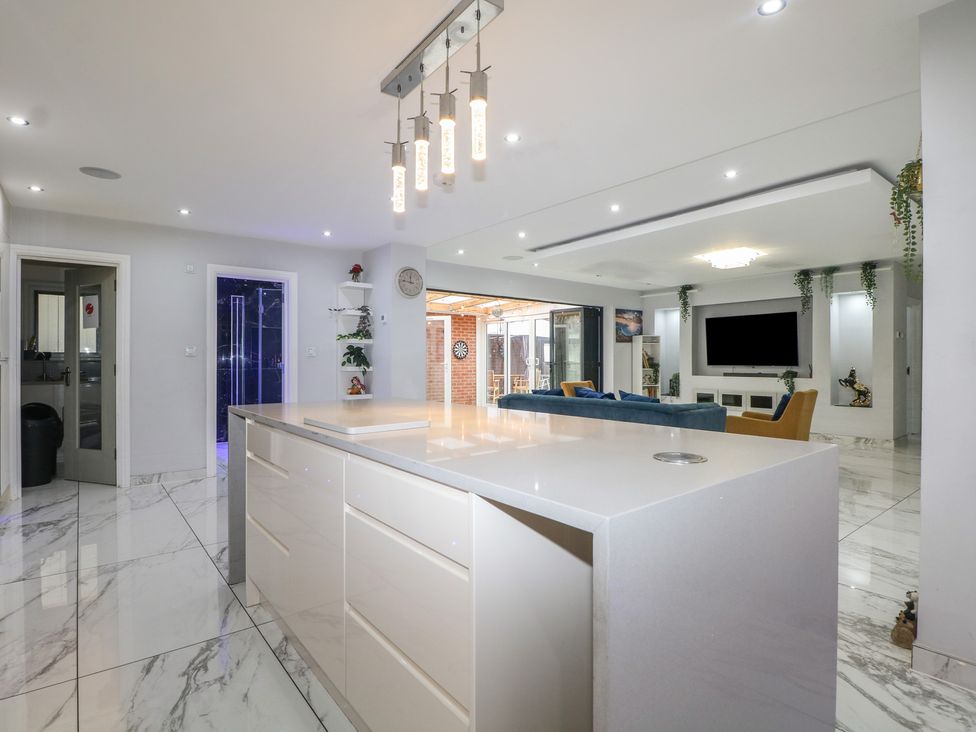 A kitchen with an island and living room area at Falcon Bal House