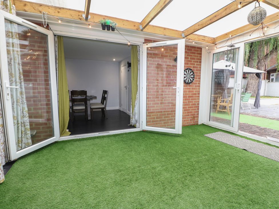 A conservatory with double doors and a dining area at Falcon Bal House