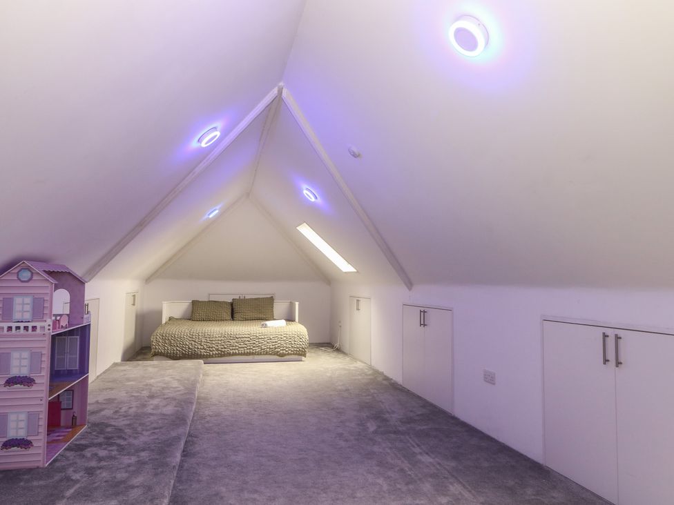 A bedroom with a bed, a dollhouse, and cupboards at Falcon Bal House