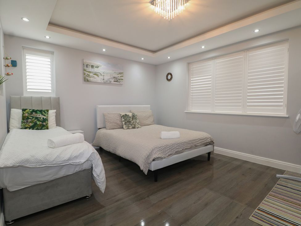 A bedroom with two beds, windows and a picture at Falcon Bal House