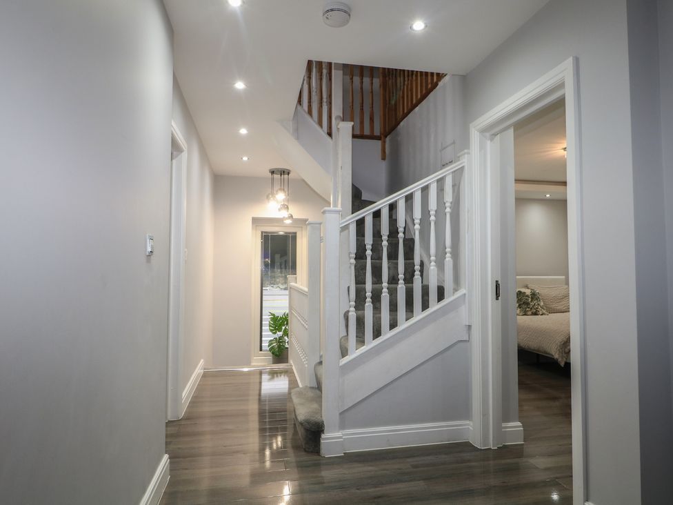 A hallway with a staircase and a door at Falcon Bal House