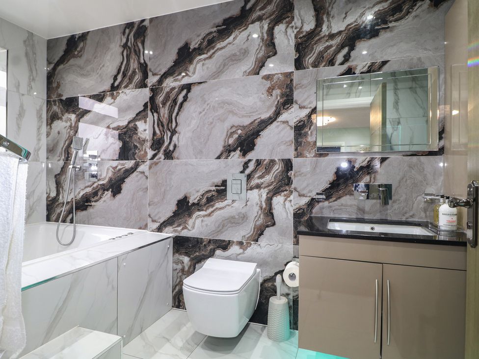 A bathroom with a bathtub, toilet, and sink at Falcon Bal House